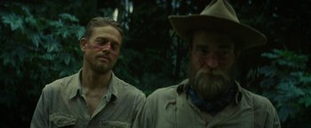 Movie still from “The Lost City of Z” (2016), directed by James Gray – Two men standing next to each other in the woods; Close Up shot, Over the shoulder angle