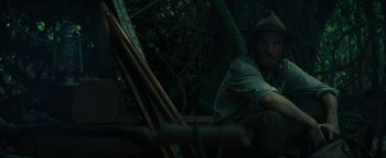 Movie still from “The Lost City of Z” (2016), directed by James Gray – A man sitting on a bench in the woods; Medium shot, Low angle