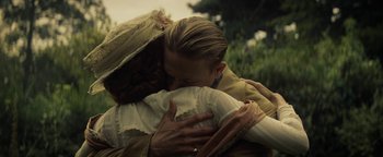 Movie still from “The Lost City of Z” (2016), directed by James Gray – Two people hugging each other in a grassy area; Medium shot, Over the shoulder angle