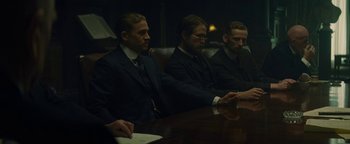 Movie still from “The Lost City of Z” (2016), directed by James Gray – A group of men sitting at a table in a room; Medium shot, Over the shoulder angle