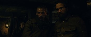 Movie still from “The Lost City of Z” (2016), directed by James Gray – Two men standing next to each other in the dark; Medium shot, Over the shoulder angle