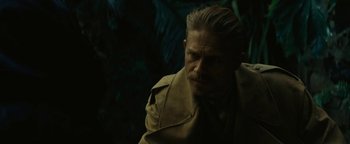 Movie still from “The Lost City of Z” (2016), directed by James Gray – A man in a trench coat looking to his left; Close Up shot, Over the shoulder angle