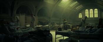 Movie still from “The Lost City of Z” (2016), directed by James Gray – A group of people in a room with beds; Wide shot, High angle