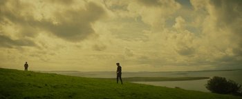 Movie still from “The Lost City of Z” (2016), directed by James Gray – A man standing on top of a green hill; Extreme Wide shot, Low angle