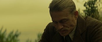 Movie still from “The Lost City of Z” (2016), directed by James Gray – An older man with a mustache is looking down; Close Up shot, Over the shoulder angle