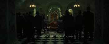 Movie still from “The Lost City of Z” (2016), directed by James Gray – A group of people standing in a room; Extreme Wide shot, High angle