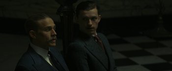 Movie still from “The Lost City of Z” (2016), directed by James Gray – A man in a suit standing next to another man in a suit; Medium shot, Low angle
