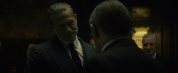 Movie still from “The Lost City of Z” (2016), directed by James Gray – A man in a suit and tie talking to another man in a suit and tie; Close Up shot, Over the shoulder angle