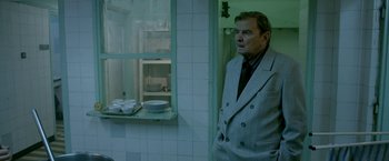 Movie still from “The Lure” (2015), directed by Agnieszka Smoczynska – A man standing in front of a window in a room; Medium shot, Over the shoulder angle