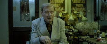 Movie still from “The Lure” (2015), directed by Agnieszka Smoczynska – An older man wearing a suit and a tie; Medium shot, Over the shoulder angle