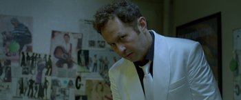 Movie still from “The Lure” (2015), directed by Agnieszka Smoczynska – A man wearing a white suit and a black tie; Close Up shot, Low angle