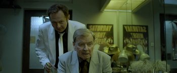 Movie still from “The Lure” (2015), directed by Agnieszka Smoczynska – A man in a suit and tie next to another man in a tie; Medium shot, Low angle