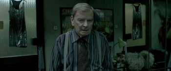 Movie still from “The Lure” (2015), directed by Agnieszka Smoczynska – An older man wearing a striped shirt and a tie; Medium shot, Over the shoulder angle