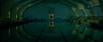 Movie still from “The Lure” (2015), directed by Agnieszka Smoczynska – A man standing in front of an indoor swimming pool at night; Extreme Wide shot, Low angle