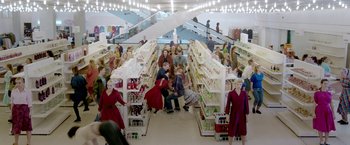 Movie still from “The Lure” (2015), directed by Agnieszka Smoczynska – A group of people sitting in a store aisle; Extreme Wide shot, High angle
