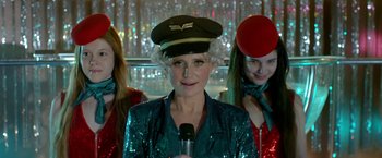 Movie still from “The Lure” (2015), directed by Agnieszka Smoczynska – A woman with a microphone and two other women; Close Up shot, Over the shoulder angle