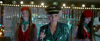 Movie still from “The Lure” (2015), directed by Agnieszka Smoczynska – A woman in a hat holding up a microphone; Medium shot, Over the shoulder angle