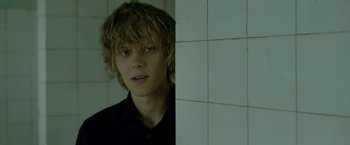 Movie still from “The Lure” (2015), directed by Agnieszka Smoczynska – A young man with blonde hair and a black shirt; Close Up shot, Over the shoulder angle