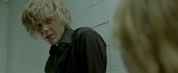 Movie still from “The Lure” (2015), directed by Agnieszka Smoczynska – A man with blonde hair wearing a black shirt; Close Up shot, Over the shoulder angle