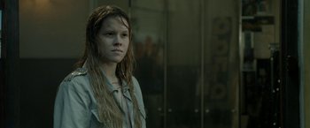 Movie still from “The Lure” (2015), directed by Agnieszka Smoczynska – A woman with long hair standing in front of a glass wall; Close Up shot, Low angle