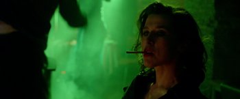 Movie still from “The Lure” (2015), directed by Agnieszka Smoczynska – A woman is smoking a cigarette in front of a green background; Close Up shot, Over the shoulder angle
