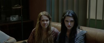Movie still from “The Lure” (2015), directed by Agnieszka Smoczynska – Two young women sitting next to each other on a couch; Close Up shot, Low angle