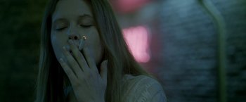 Movie still from “The Lure” (2015), directed by Agnieszka Smoczynska – A woman with her hand on her face holding a cigarette; Close Up shot, Low angle