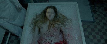 Movie still from “The Lure” (2015), directed by Agnieszka Smoczynska – A woman with long blonde hair laying in ice; Medium shot, Overhead angle