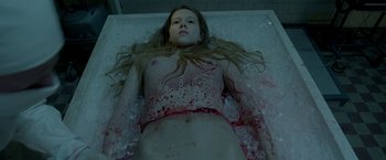 Movie still from “The Lure” (2015), directed by Agnieszka Smoczynska – A woman laying on the ground covered in blood; Medium shot, High angle
