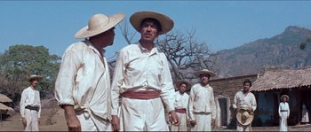 Movie still from “The Magnificent Seven” (1960), directed by John Sturges – A group of men standing next to each other wearing hats; Medium shot, Low angle