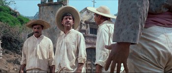 Movie still from “The Magnificent Seven” (1960), directed by John Sturges – A man wearing a straw hat standing next to another man wearing a straw hat; Medium shot, Low angle