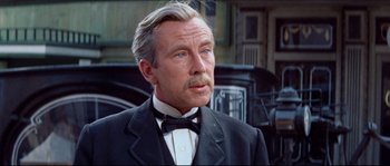 Movie still from “The Magnificent Seven” (1960), directed by John Sturges – An older man wearing a suit and a bow tie; Close Up shot, Over the shoulder angle