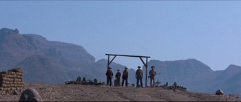 Movie still from “The Magnificent Seven” (1960), directed by John Sturges – A group of men standing on top of a dirt field; Wide shot, Low angle