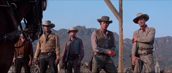 Movie still from “The Magnificent Seven” (1960), directed by John Sturges – A group of men standing on top of a hill; Medium shot, Low angle