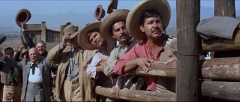 Movie still from “The Magnificent Seven” (1960), directed by John Sturges – A group of men standing next to each other wearing hats; Medium shot, Low angle