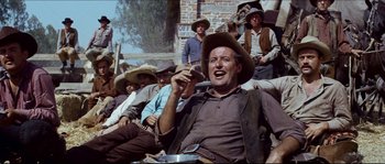 Movie still from “The Magnificent Seven” (1960), directed by John Sturges – A group of men sitting on a wall; Medium shot, Low angle