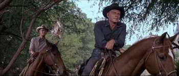 Movie still from “The Magnificent Seven” (1960), directed by John Sturges – A man sitting on top of a brown horse; Medium shot, Low angle