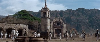 Movie still from “The Magnificent Seven” (1960), directed by John Sturges – A group of people standing around a church; Extreme Wide shot, Low angle