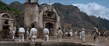Movie still from “The Magnificent Seven” (1960), directed by John Sturges – A group of people standing in front of a building; Extreme Wide shot, Low angle