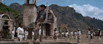 Movie still from “The Magnificent Seven” (1960), directed by John Sturges – A group of people standing in front of an old church; Wide shot, Low angle