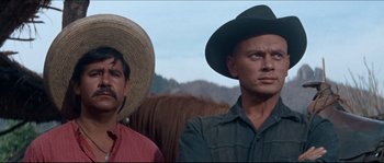 Movie still from “The Magnificent Seven” (1960), directed by John Sturges – Two men wearing hats and standing next to each other; Close Up shot, Low angle