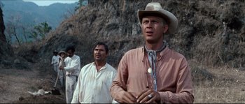 Movie still from “The Magnificent Seven” (1960), directed by John Sturges – A man wearing a cowboy hat standing next to two other men; Medium shot, Low angle