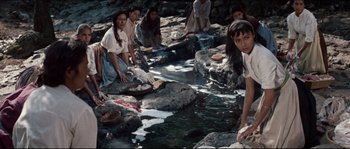 Movie still from “The Magnificent Seven” (1960), directed by John Sturges – A group of women washing dishes in a river; Medium shot, High angle