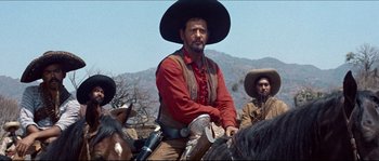 Movie still from “The Magnificent Seven” (1960), directed by John Sturges – A man wearing a cowboy hat sitting on top of a horse; Medium shot, Low angle