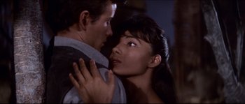 Movie still from “The Magnificent Seven” (1960), directed by John Sturges – A man and a woman embracing each other in front of a wall; Close Up shot, High angle