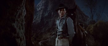 Movie still from “The Magnificent Seven” (1960), directed by John Sturges – A man standing in front of a mountain at night; Medium shot, Low angle