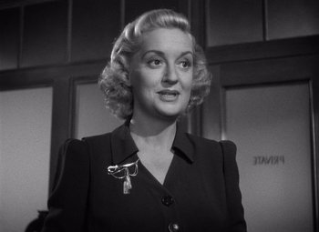 Movie still from “The Maltese Falcon” (1941), directed by John Huston – An old photo of a woman in a black suit; Close Up shot, High angle