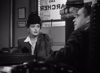 Movie still from “The Maltese Falcon” (1941), directed by John Huston – An old photo of a woman and a man sitting at a table; Medium shot, Over the shoulder angle