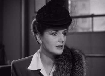 Movie still from “The Maltese Falcon” (1941), directed by John Huston – A woman wearing a black hat and a fur collar; Close Up shot, Over the shoulder angle