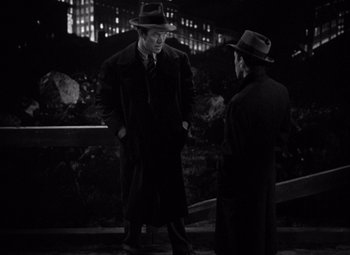 Movie still from “The Maltese Falcon” (1941), directed by John Huston – Two men are standing outside talking to each other; Medium shot, Low angle